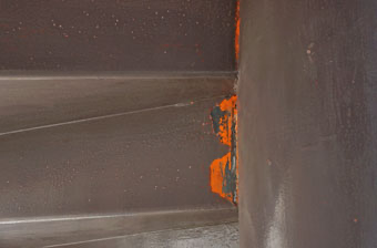 マンションの非常階段の塗装がはがれて赤茶色が見えているときには錆が発生している画像